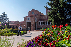 The exterior of a building on campus of UC Boulder with a flower garden